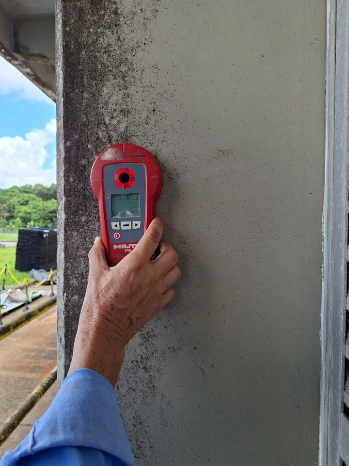 Pacometria — localização de armaduras com detector em pilar de concreto: aparelho vermelho encostado na face do pilar por um técnico da LACROSE.