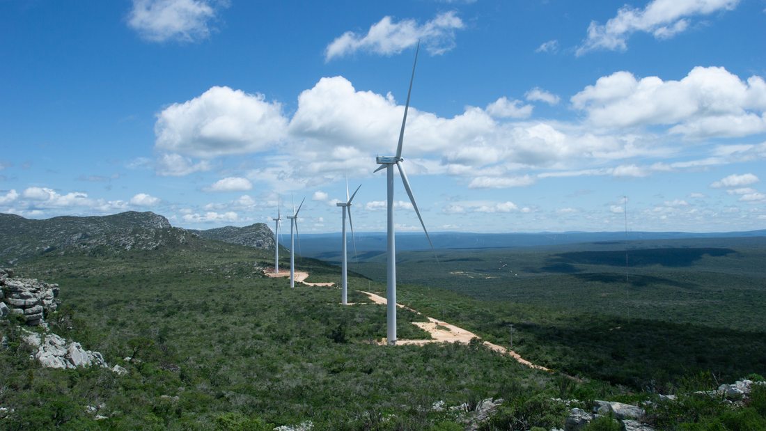 Aerogeradores do Parque Eólico de Caetité, na Bahia, alinhados sobre a encosta sob céu azul — controle tecnológico dos materiais e monitoramento de temperatura do concreto.